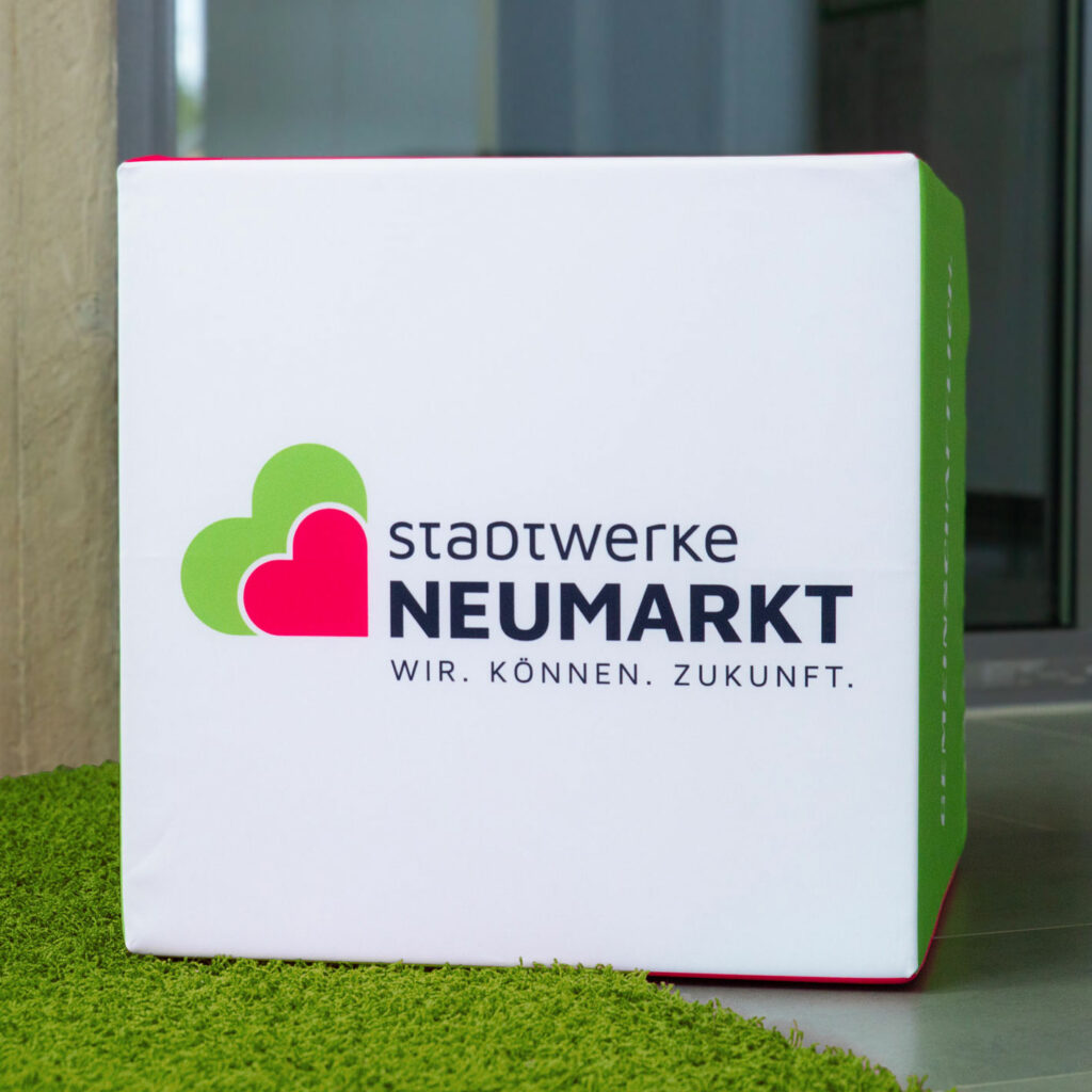 Neues Logo der Stadtwerke Neumarkt, dargestellt auf einem Sitzwürfel