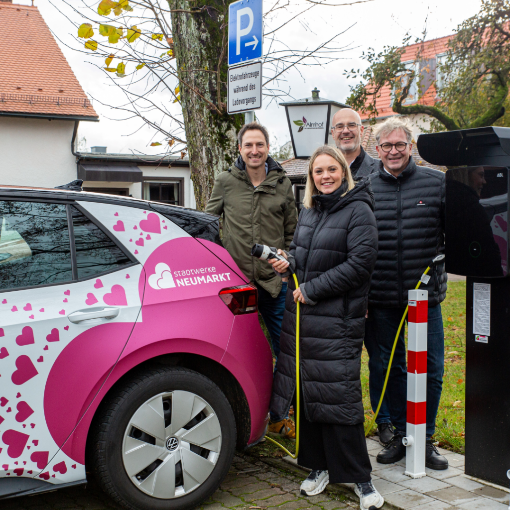 Matthias Lehmeier, Viktoria Lukas, Dominique Kinzkofer und Georg Lukas wehen Ladesäule am Hotel AlmRefugio ein