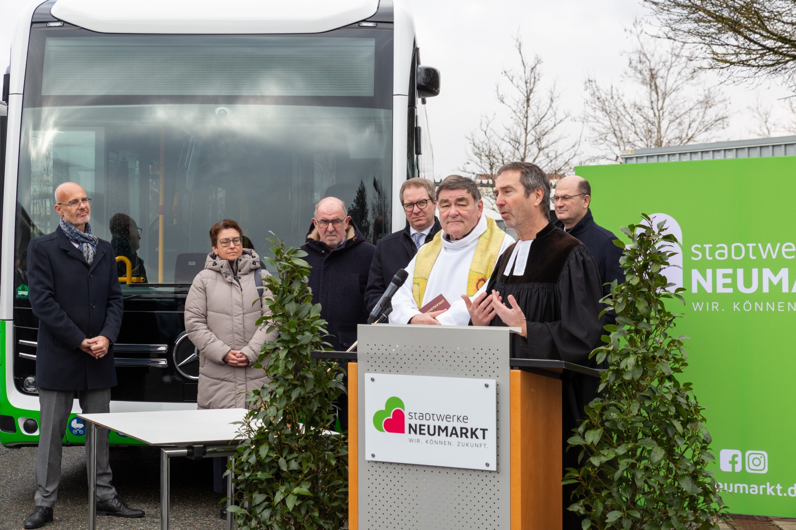 Pfarrer Murner spricht am Rednerpult bei der Weihung der E-Busse